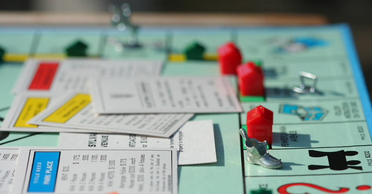 Monopoly board pieces and property cards used as a visual metaphor for market concentration and monopoly power in Argentina.